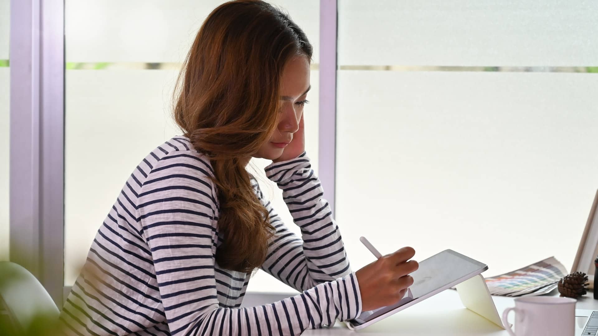 Femme de profil dessinant sur sa tablette - agence de communication montpellier – Diadao