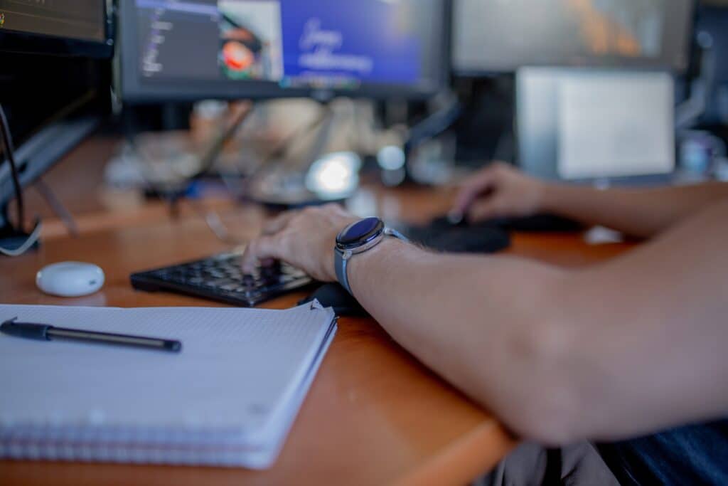 Personne tapant sur clavier avec ordinateur.