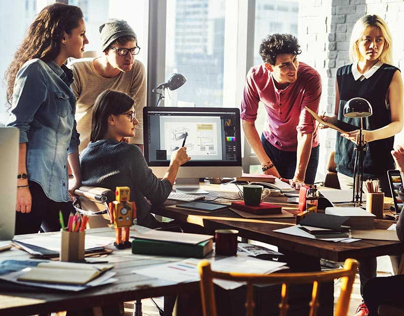Équipe collaborant autour d'un ordinateur au bureau.