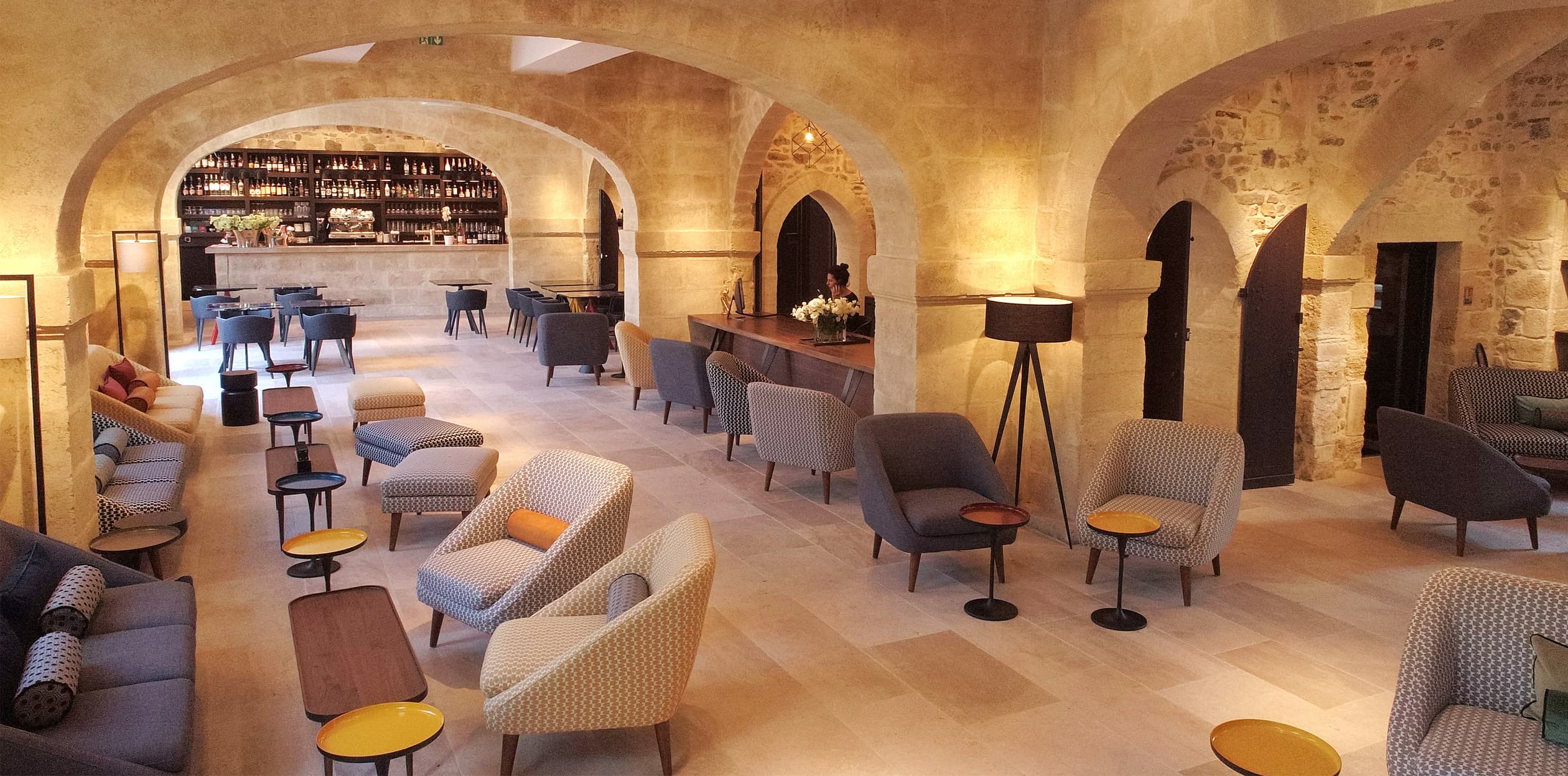Salon élégant avec fauteuils et tables basses.