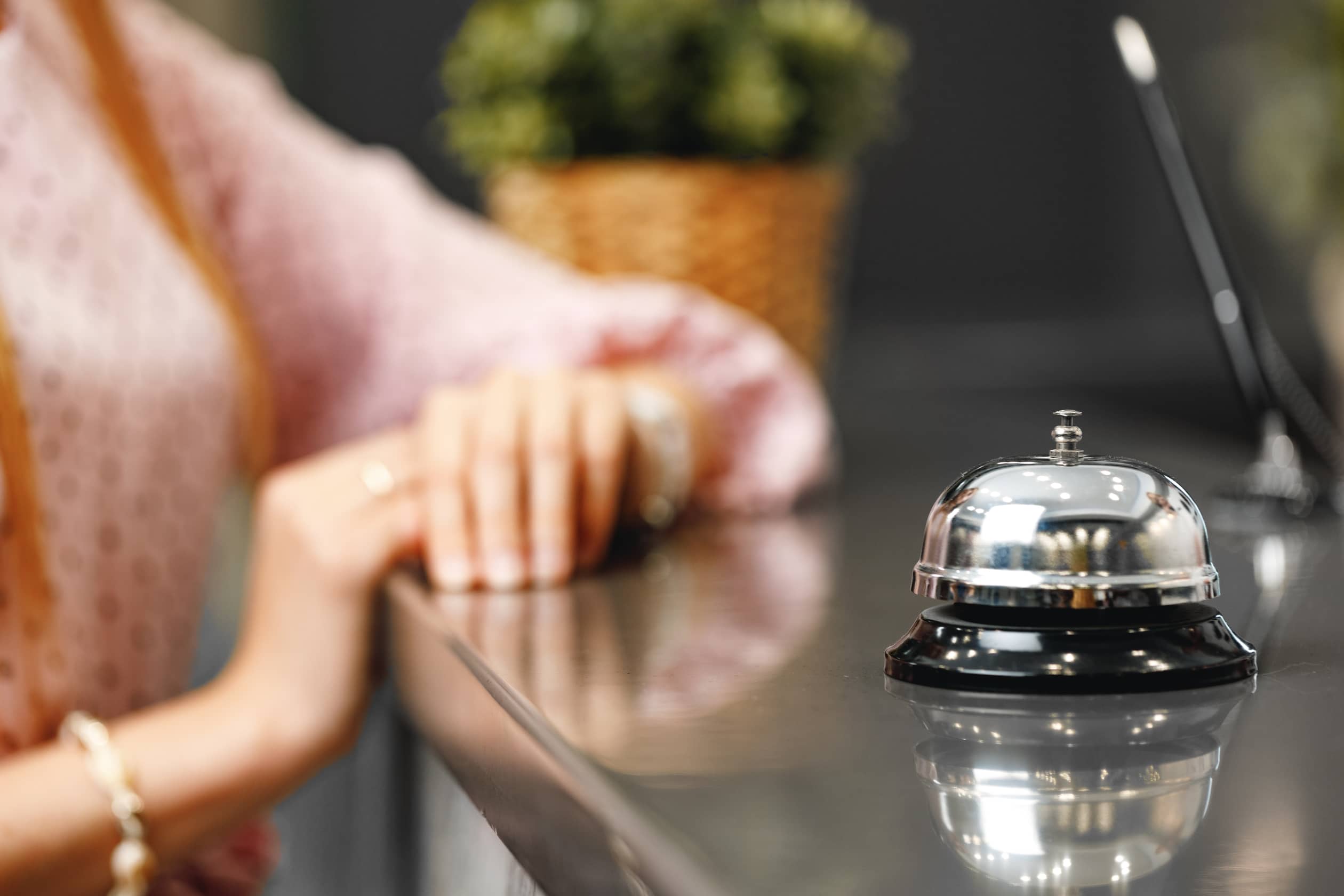 blonde woman standing at front desk hotel reception